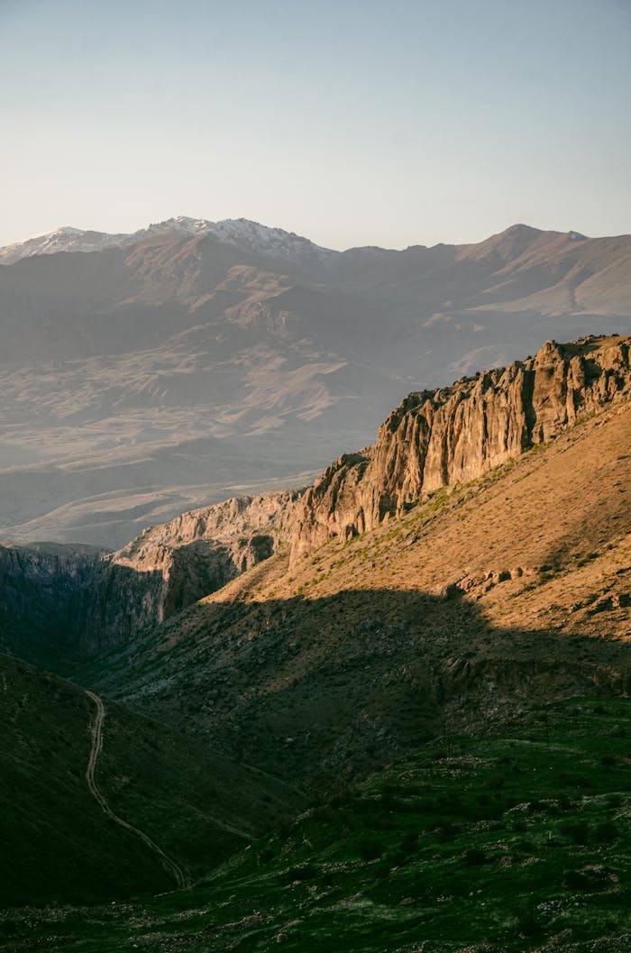 A vast and rugged mountain landscape basked in the warm glow of the sunrise.